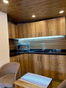 a kitchen with wooden cabinets and a sink and a table at Welcome to our home in Beirut
