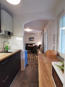 a kitchen and dining room with a table in the background at Apartman Magdalena in Cres +10 photos