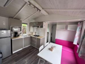 a small kitchen with a white table and a pink couch at Schilke24 - A017 in Boofzheim