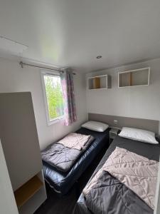 a small room with two beds and a window at Schilke24 - A017 in Boofzheim