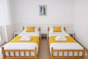 zwei Betten in einem Zimmer mit gelben und weißen in der Unterkunft Hotel Konty Self-Service in Kąty Opolskie