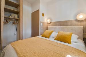 a bedroom with a large bed with yellow pillows at T2 Haut de gamme avec jardin privé - 50m du port Miramar in La Londe-les-Maures
