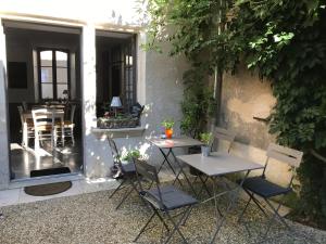 a patio with two tables and chairs in front of a building at Chambres d'hôtes de La Tour Morillon in Saint-Amand-Montrond