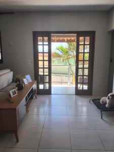 a living room with doors and a dog laying on the floor at Hostel caminho da Serra in São Pedro