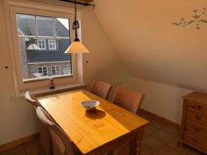 a dining room table with chairs and a bowl on it at Sütjers Hüs in Norddorf