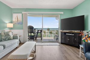 a living room with a couch and a flat screen tv at 6405 Gulf Shores Plantation-Palms in Gulf Shores