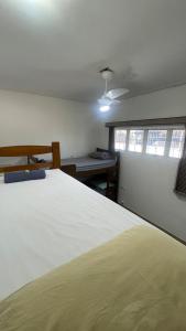 a bedroom with a large white bed and a window at Casa para 8 pessoas in Itu