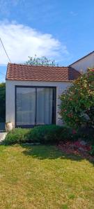 a house with a window and a cat sitting in the yard at le Pressoir Doretz in Arthon-en-Retz