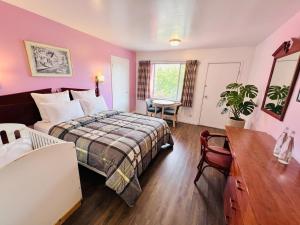 a bedroom with a bed and a desk and a table at Persepolis Inn in Niagara Falls
