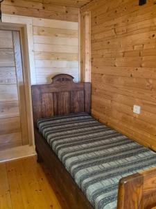 a bed in a room with a wooden wall at Cosy Village in Šentjernej +54 photos