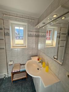 a bathroom with a sink and a mirror at Sütjers Hüs in Norddorf +58 photos