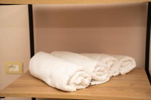 a row of white towels sitting on a shelf at Bar Hotel Orgito in Lushnjë +160 photos