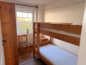 two bunk beds in a room with a window at Sütjers Hüs in Norddorf