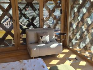a white chair sitting on a porch next to a window at Cosy Village in Šentjernej