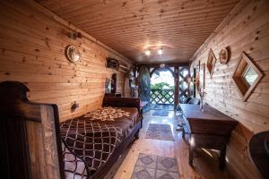 a bedroom in a log cabin with a bed and a desk at Cosy Village in Šentjernej