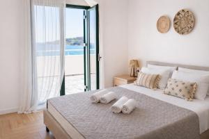 a bedroom with a large bed with towels on it at Elysian Seaside Villa in Almyrida
