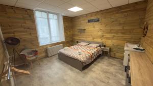 a bedroom with a bed in a room with wooden walls at Le Cocon de Sasha - Hyper Centre - Climatisation - Proche Gare in Verdun-sur-Meuse