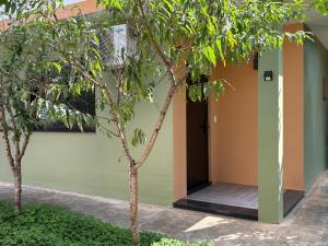 a building with a door and two trees at Estúdio com suíte super confortável no centro in Ijuí