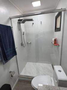 a bathroom with a glass shower with a toilet at Estúdio com suíte super confortável no centro in Ijuí +16 photos