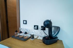 a table with a blender and wine glasses on it at SEE YOU Apartments in Niš