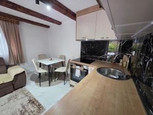 a kitchen with a sink and a table in a room at Sunrise Skadar lake in Braćeni