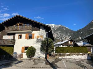 a house in a parking lot with mountains in the background at Zugspitze 6 mit SAUNA in Farchant bei Garmisch-Partenkirchen in Farchant