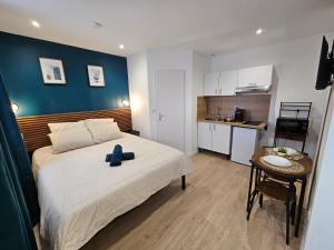 a bedroom with a large bed and a small kitchen at LD Atmosphère in Saint-Quentin +32 photos