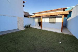 a courtyard of a house with a grass yard at Mar Azul Beach House in Cabo Frio