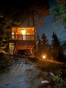 a tree house in the woods at night at Ravn in Vistad