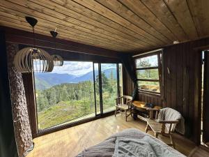 a bedroom with a bed and a desk and windows at Ravn in Vistad