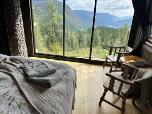 a bedroom with a bed and a large window at Ravn in Vistad +8 photos