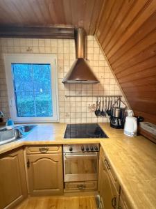 a kitchen with a stove and a sink and a window at Ferienhaus am Mescheriner See in Mescherin