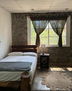 a bedroom with a bed and a large window at Atlakamani Surf in Chirilagua