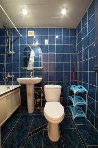 アストラハンにあるKvartira Klass Apartments at Chekhova 103の青いタイル張りのバスルーム(トイレ、シンク付)