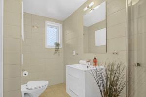 a bathroom with a toilet and a sink and a mirror at Contemporary city-apartement with views of the dock! in Bergen +16 photos