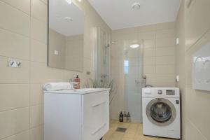 a bathroom with a washing machine and a washer at Contemporary city-apartement with views of the dock! in Bergen