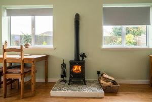 a kitchen with a stove in a room with a table at Stylish Morpeth Cottage with Log Burner, Garden and Free Parking in Morpeth