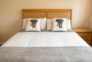 a bed with white sheets and pillows at Stylish Morpeth Cottage with Log Burner, Garden and Free Parking in Morpeth