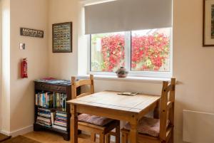 a table and chairs in a room with a window at Stylish Morpeth Cottage with Log Burner, Garden and Free Parking in Morpeth