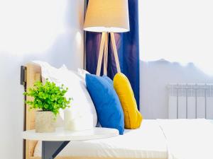 a bed with pillows and a table with a lamp at 417I2 Gray and Yellow apartment Sholpan city in Almaty