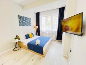 a bedroom with a bed and a flat screen tv at 417I2 Gray and Yellow apartment Sholpan city in Almaty