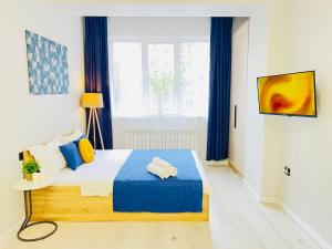 a bedroom with a large bed with blue and yellow pillows at 417I2 Gray and Yellow apartment Sholpan city in Almaty