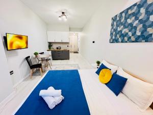 a bedroom with a large bed with blue and yellow pillows at 417I2 Gray and Yellow apartment Sholpan city in Almaty