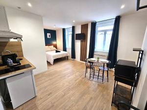 a kitchen and a living room with a bed and a table at LD Atmosphère in Saint-Quentin