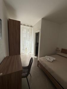 a bedroom with a bed and a desk and a window at Chiara 3 in Cairo Montenotte