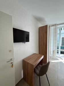 a room with a table and a chair and a television at Chiara 3 in Cairo Montenotte