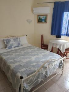 a bedroom with a bed and a blue curtain at Residencial Monte Sintinha in Espargos