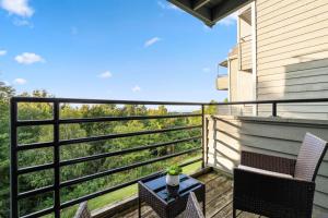 a balcony with two chairs and a table with a view at Above the Trees - Modern Studio for 2 with Views, Wifi, Pools in Gatlinburg