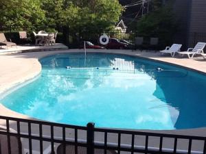 a large swimming pool with blue water at Above the Trees - Modern Studio for 2 with Views, Wifi, Pools in Gatlinburg +95 photos