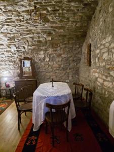 a dining room with a table in a stone wall at Jeanette's Home in Berat +8 photos